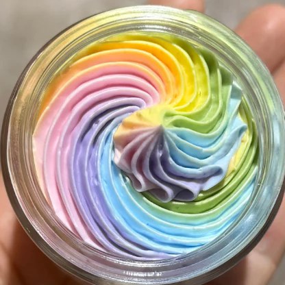 Real, unfiltered top-down photo of whipped rainbow tallow swirled in the jar