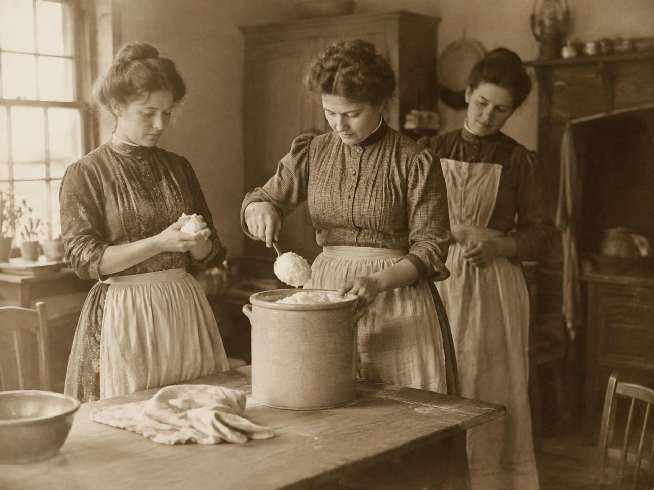 Vintage photo of women scooping whipped tallow from a crock